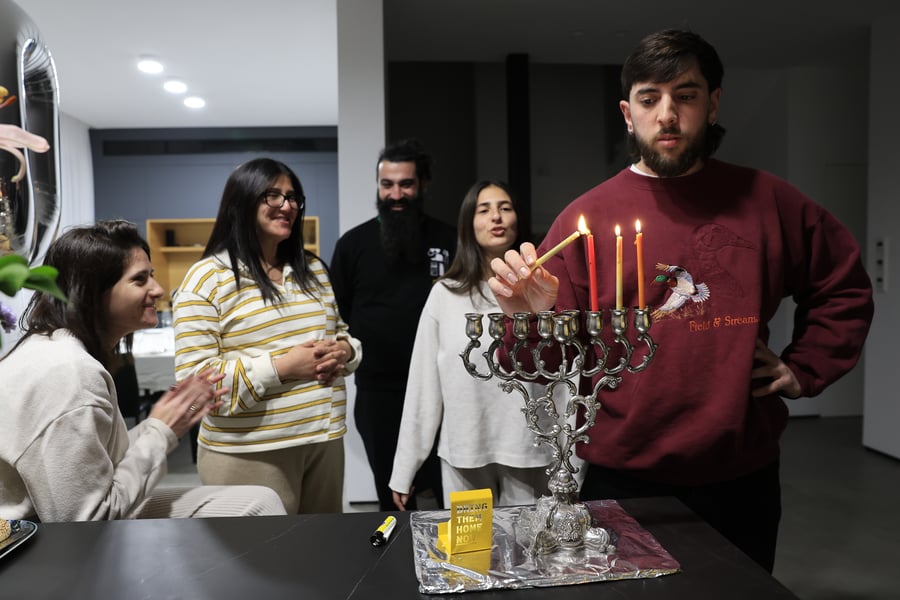 Jews light the Hanukkah candles with a candle for Israelis held hostage in Gaza, during the Jewish holiday of Hanukkah, in Mishmar David, on December 27, 2024