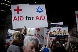 Israeli doctors hold photographs of the kidnapped people held hostage by Hamas terrorists in Gaza, as they protest outside the Red Cross headquarters in Tel Aviv, November 9, 2023.