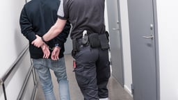 Prison guard escort arrested inmate through jail corridor