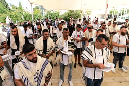 Jewish men with Tefillin and prayer shawls take part in a mass prayer as they mark the "International Day of Tefillin" at Habima Square in Tel Aviv, August 2, 2023