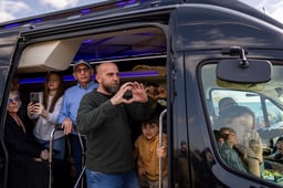 Relatives of Bibas family gesture to the crowd during the funeral service of late Israeli hostages Shiri Bibas and her children Ariel and Kfir, on road 232 in southern Israel, February 26, 2025