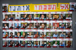 People walking next to pictures of Israelis held hostage by Hamas terrorists in Gaza, in Jerusalem, July 2, 2025. 