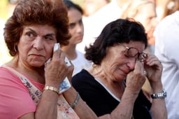 Women cry at a memorial service held in honor of the people who were killed in a terror attack on bus number 405.