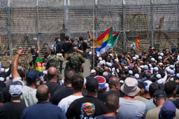 Druze residents protest near the Israeli-Syrian border fence in solidarity with their community in Syria, in Majdal Shams, July 16, 2025.