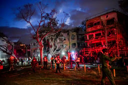 Israeli security and rescue forces at the scene where a ballistic missile fired from Iran hit and caused damage in Tel Aviv, June 17, 2025. 