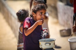 Palestinians receive meals from volunteers in Gaza City, on July 25, 2025. 