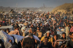 Palestinians carry food parcels and supplies from aid trucks near the Zikim border crossing between Israel and Beit Lahia, in the northern Gaza Strip, August 18, 2025.