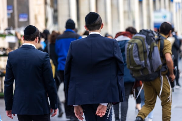Ultra orthodox yeshiva student walk past a religious soldier on Jaffa road in Jerusalem