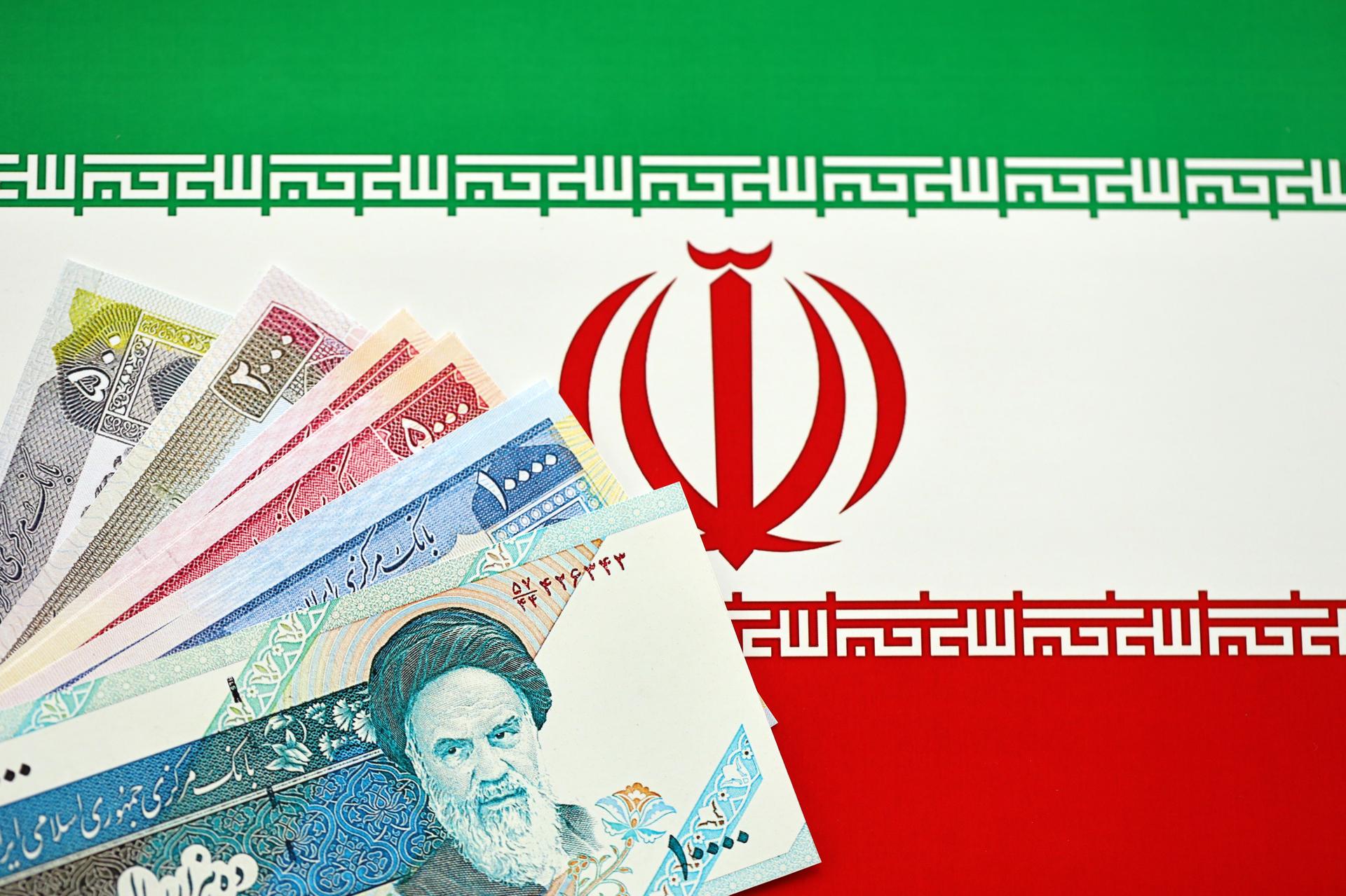 Iranian Rial IRR banknotes from Iran on flag of Islamic Republic of Iran close up
