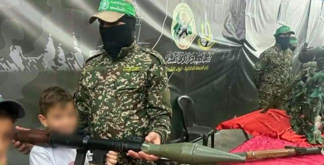 A Gazan boy next to a Hamas terrorist