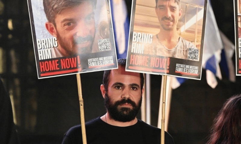 Yarden Bibas with signs of hostages David and Ariel Cunio