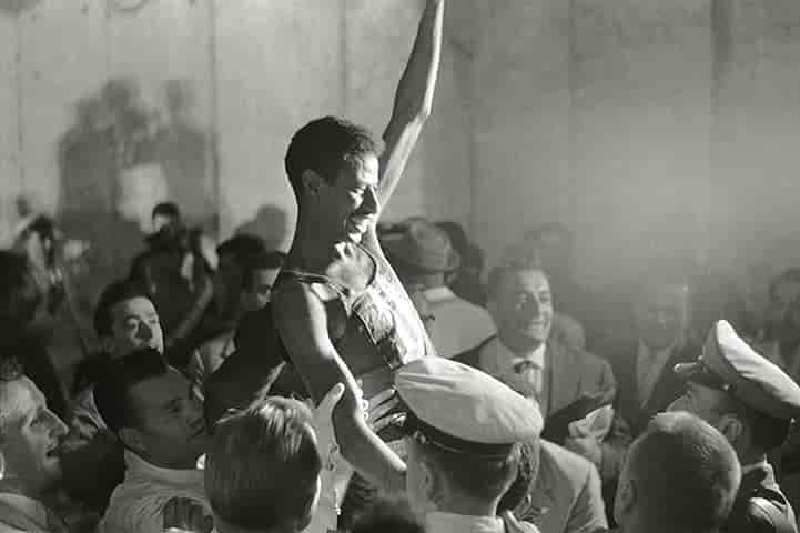 Abebe Bikila is hoisted in celebrations in Rome background