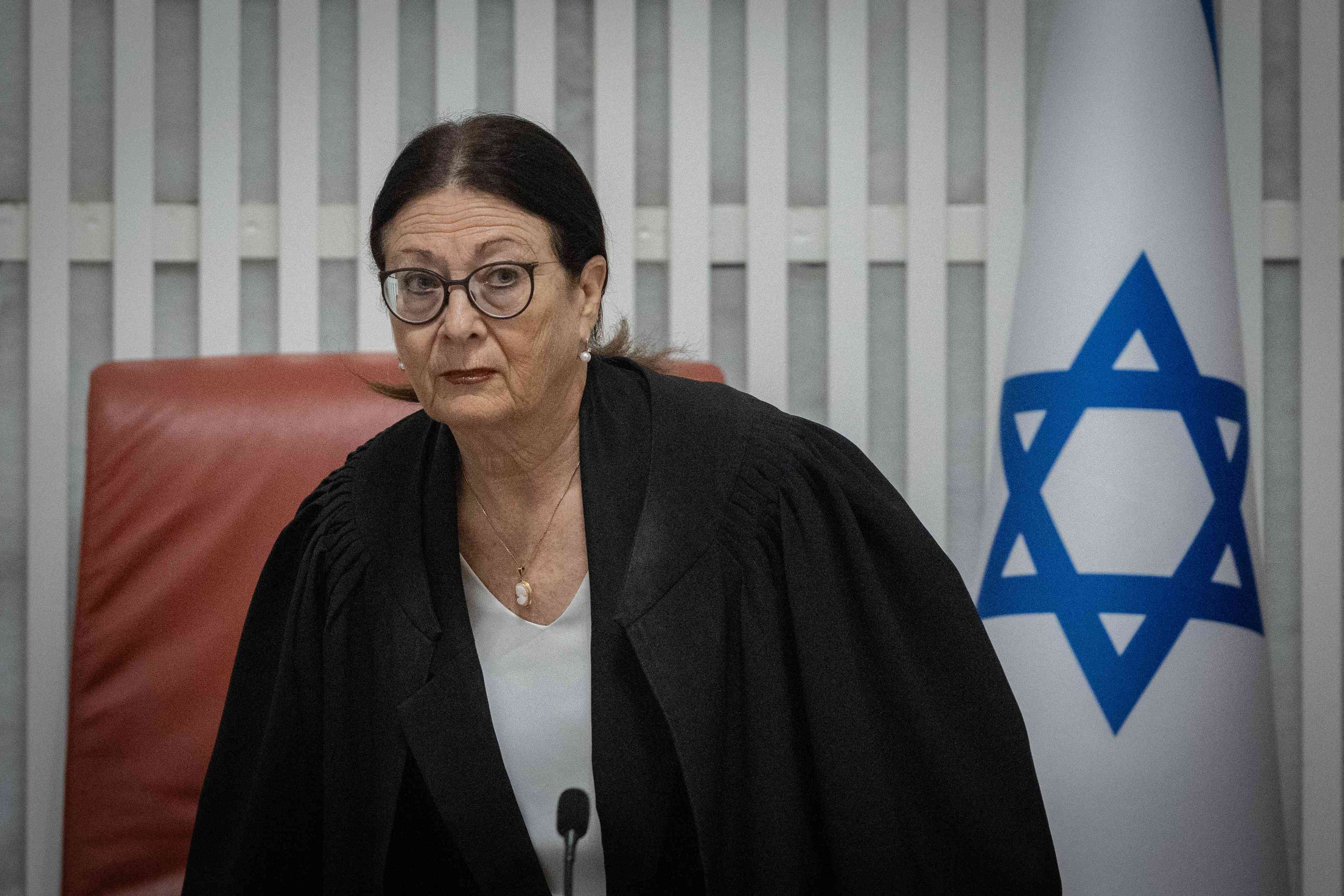 Target of a caricature connecting the Supreme Court's ruling to the war. Justice Esther Hayut. background