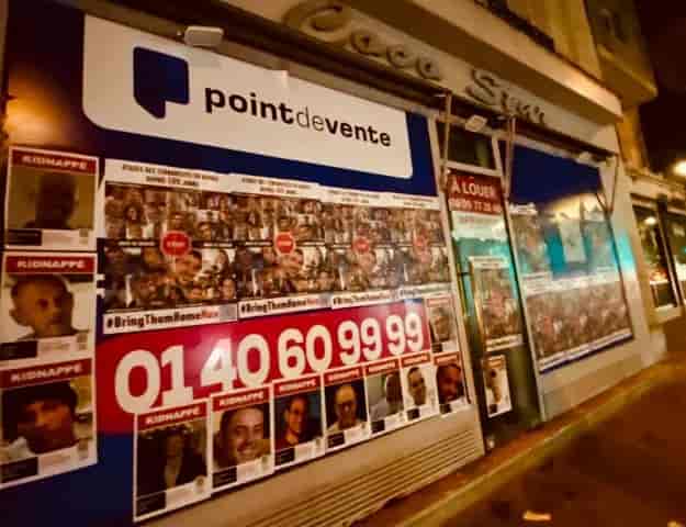 Posters of the hostages plastered all over Paris. background