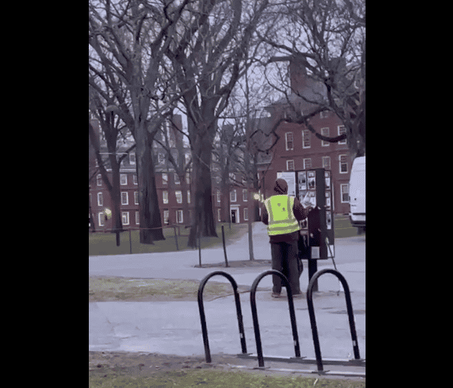 Harvard employee caught tearing down hostage posters. background