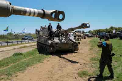 Druze families visit an IDF military weapons and equipment showcase near the Druze village of Buqata, Golan Heights. April 24, 2023. background