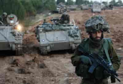 Israeli infantry reservist soldiers prepare to cross to the Gaza Strip in a deployment area near the Israeli-Gaza border background
