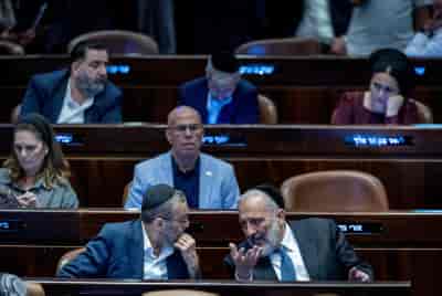MK Moshe Gafni speaks with MK Aryeh Deri in the Knesset on June 11, 2024.  background