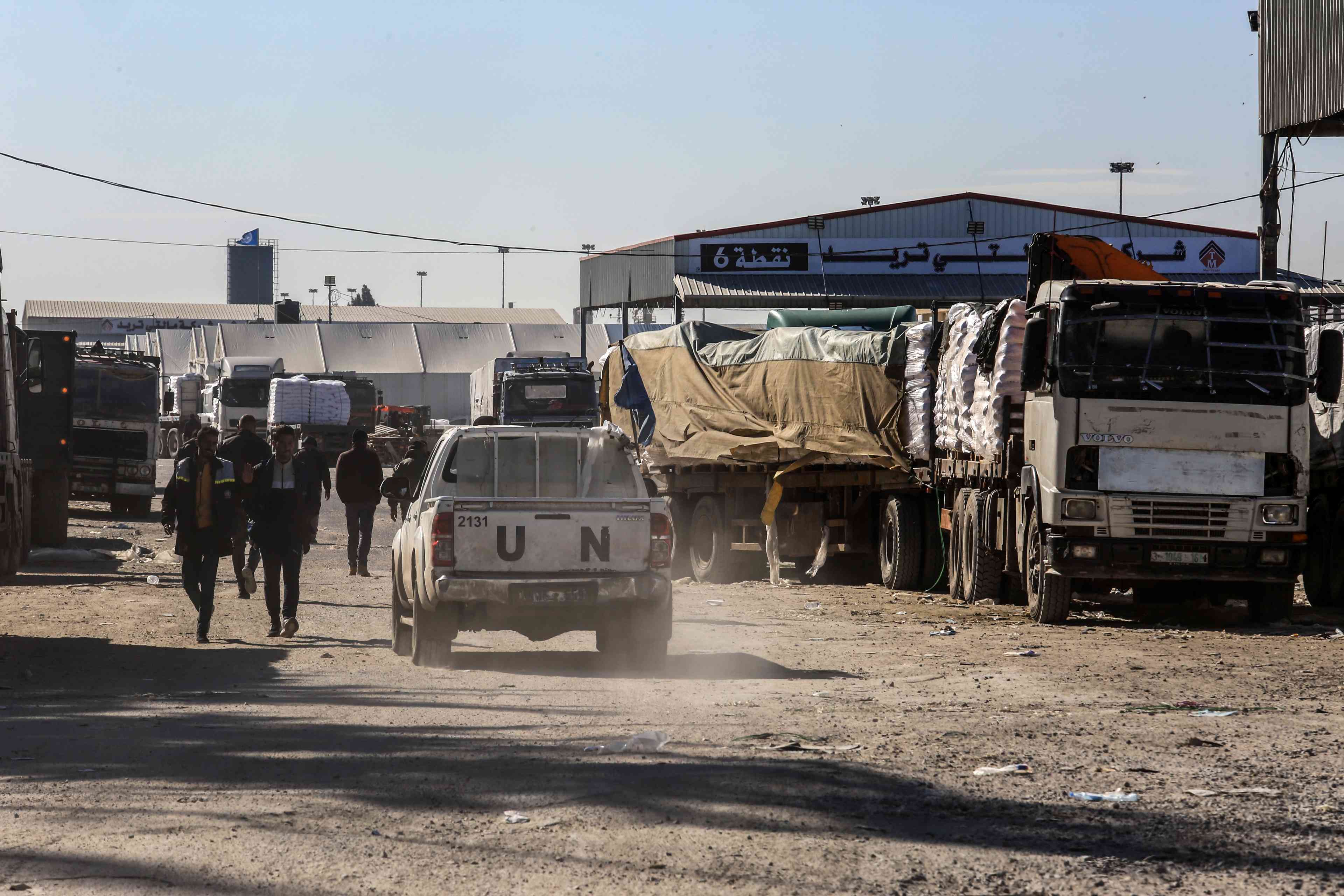 loaded with international aid enter Gaza through Kerem Shalom crossing. background