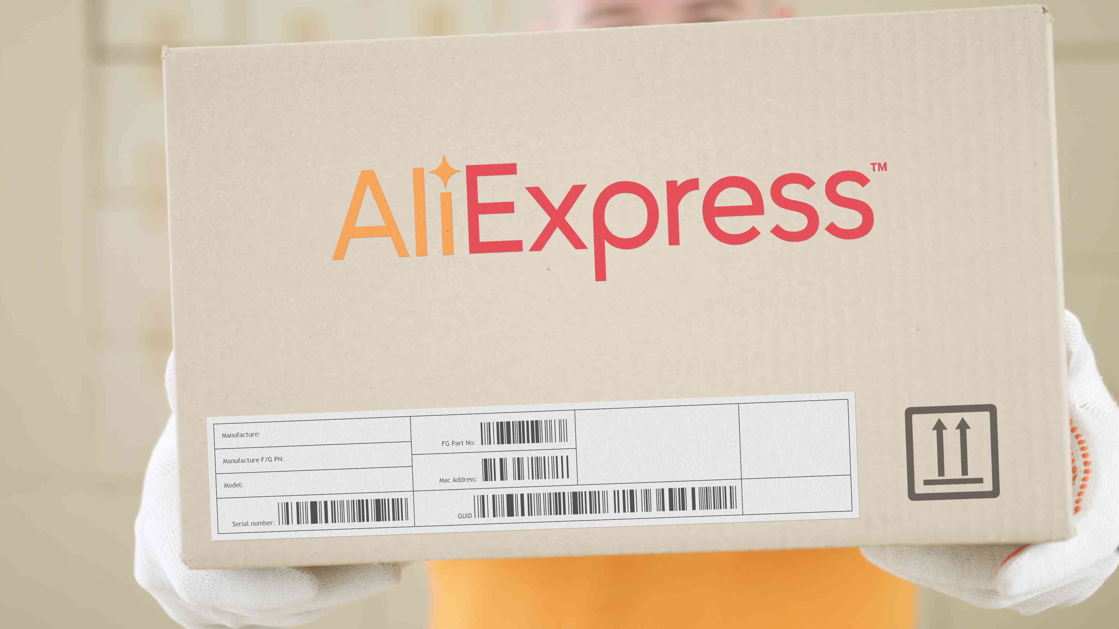 Warehouse worker holds box with printed ALIEXPRESS logo on  background
