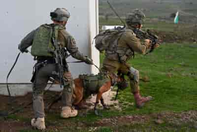 Officers of the Nachal brigade train with Israeli soldiers from the Oketz unit background