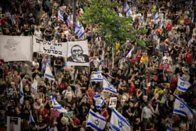 Demonstrators protest against Netanyahu, the current Israeli government and for the release of the hostages outside Hakirya Base in Tel Aviv, July 6, 2024.  background