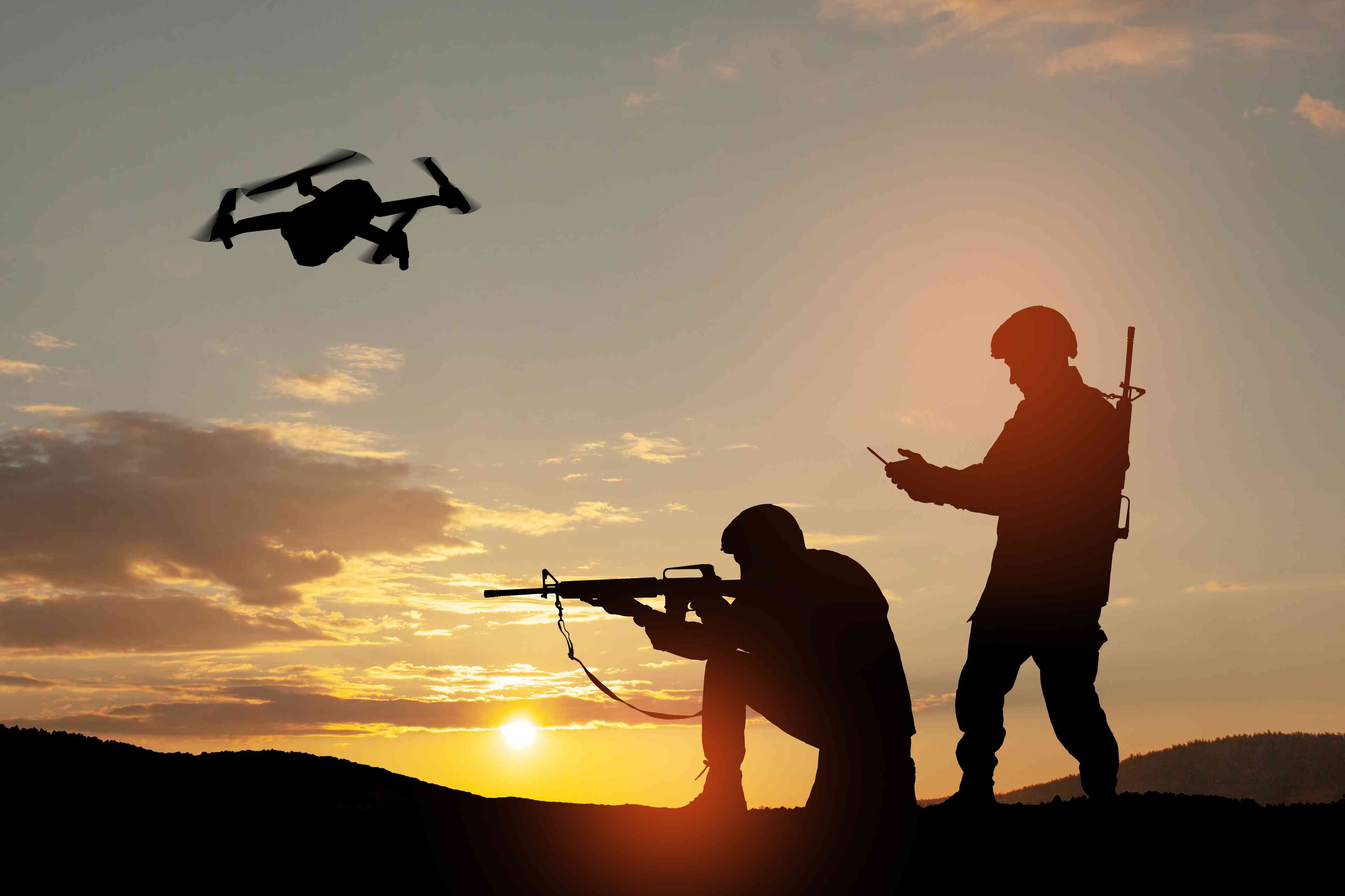 Silhouettes of soldiers using drone and laptop during military operation background