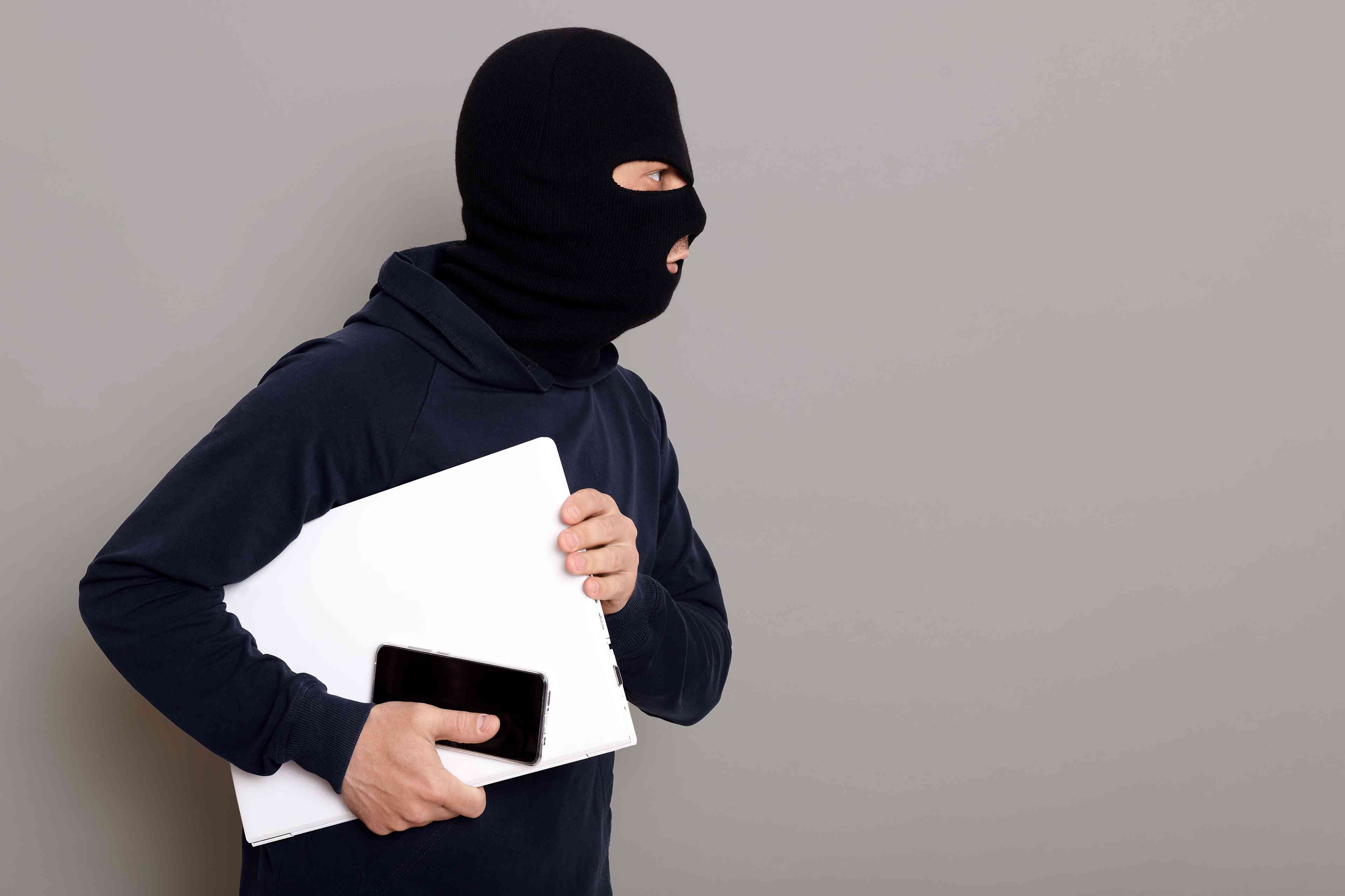 Illustrative: criminal with a stolen laptop background