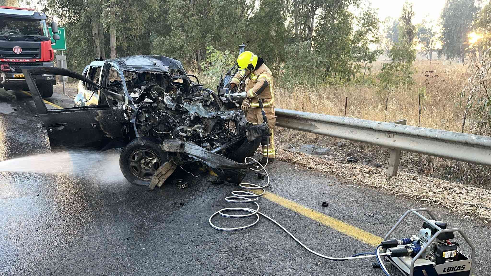 Firefighters at the scene of a rocket impact in the Golan Heights, July 9, 2024. background