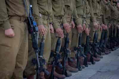 Israeli soldiers from Netzah Yeh attend a swearing-in ceremony at the Western Wall in Jerusalem's Old City, on July 10, 2024 background