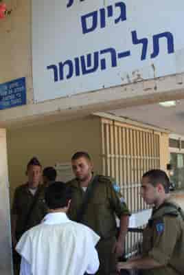Ultra-Orthodox Jewish men arrive at the Bakum Reception and Sorting base in Tel Hashomer background