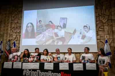 Families of Israeli observation soldiers kidnapped from Nahal Oz surveillance outpost on October 7, speak to press in Tel Aviv background