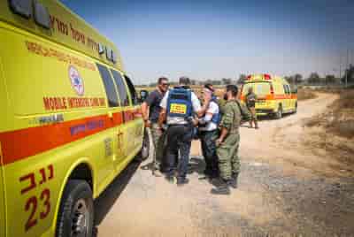 Israeli security and rescue forces near the scene where motor shells from the Gaza Strip hit an area near the Kerem Shalom crossing background
