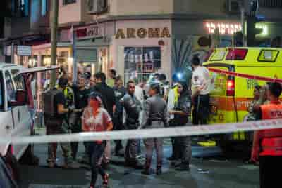 Israeli security and rescue personnel at the scene of a drone explosion in Tel Aviv on July 19, 2024 background