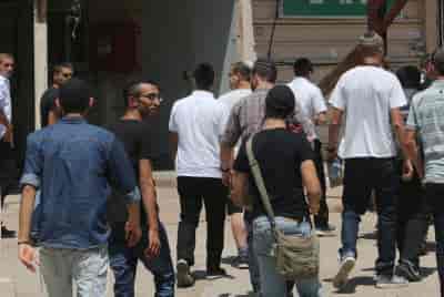 Ultra-orthodox Jewish men arrive at the Bakum Reception and Sorting base in Tel Hashomer background