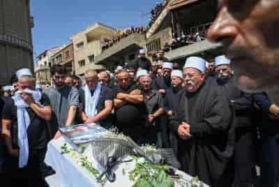 Family and friends attend the funeral service of druze children in Majdal Shams, in the Golan Heights, July 28, 2024. background
