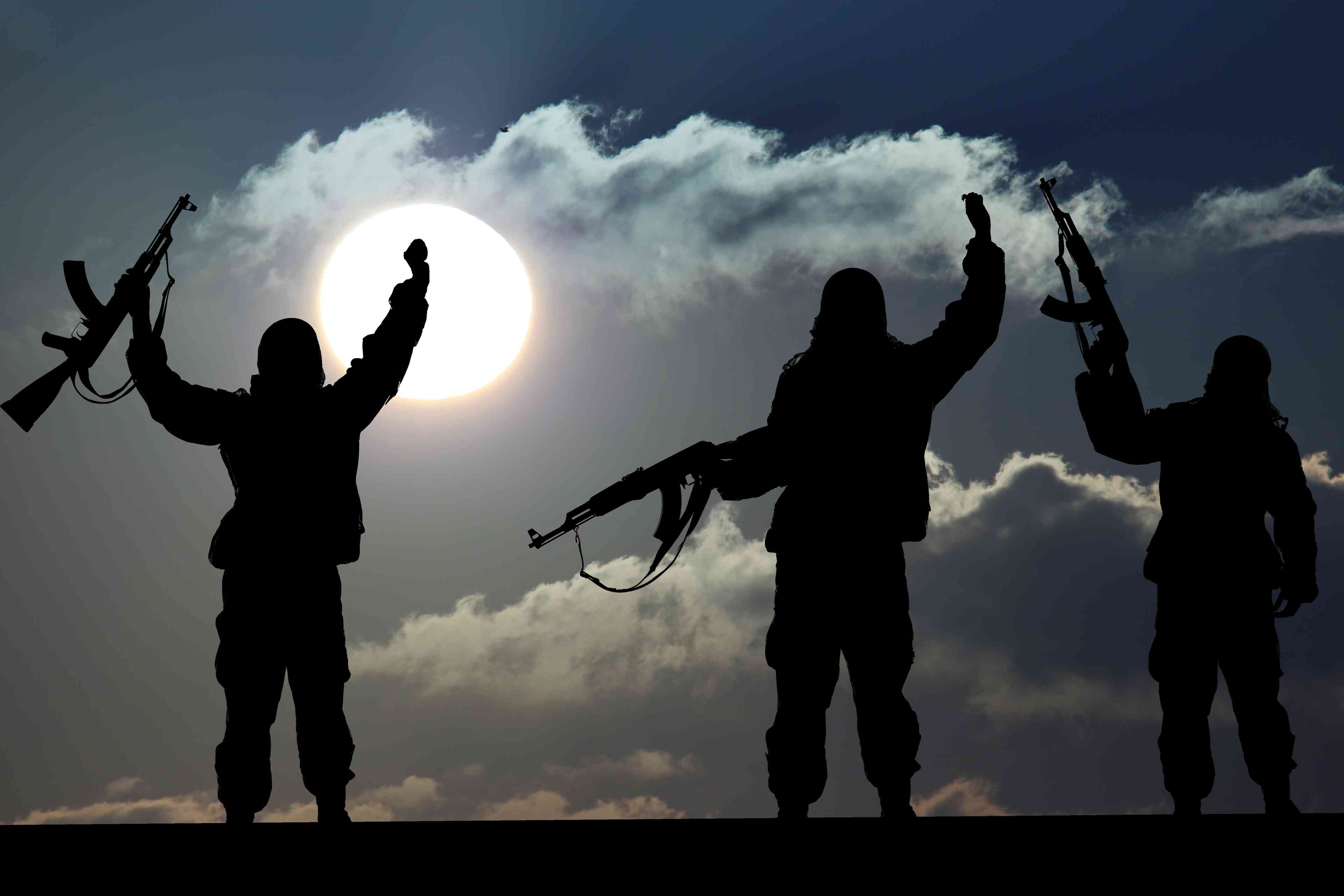 Silhouette of military soldier or officer with weapons at sunset background