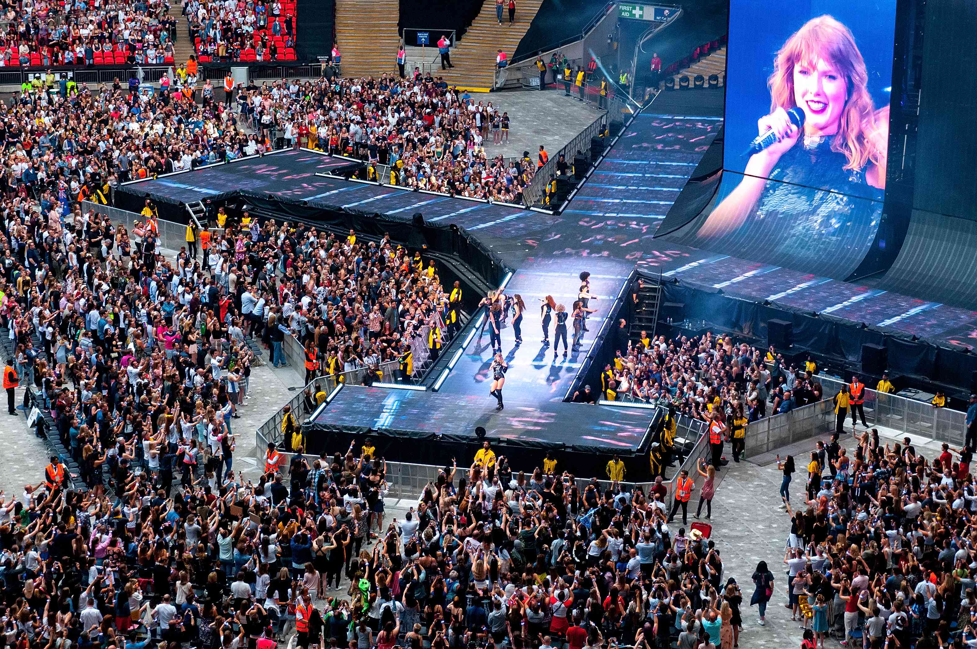 Taylor Swift performs in concert at Wembley Stadium background