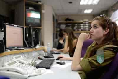 Radio broadcasters seen in the offices of Galei Tzahal, the national IDF radio station background