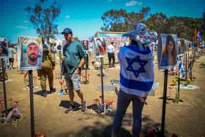 Israelis visit the site of the Re'im music festival massacre, in southern Israel background