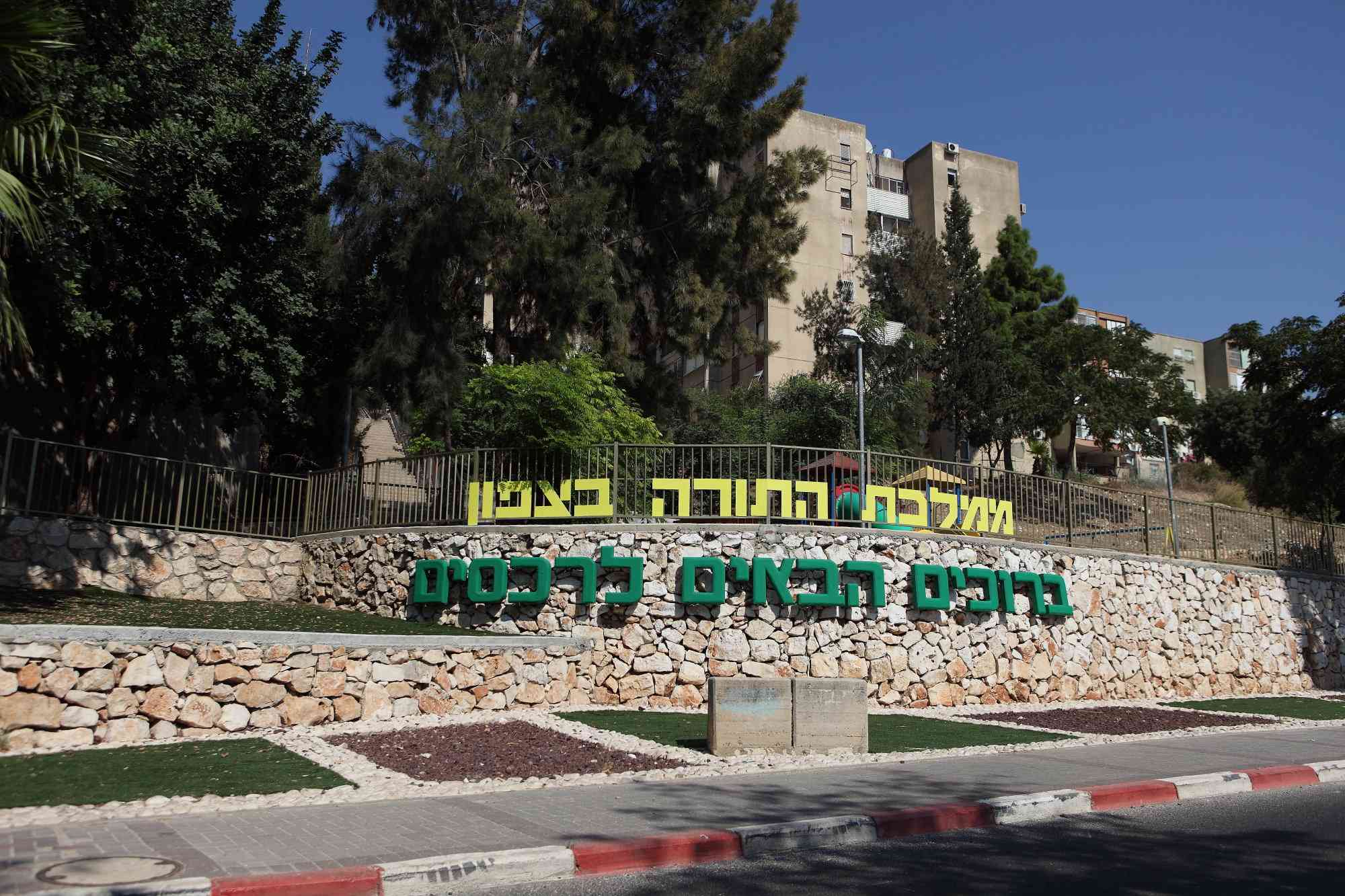 A large sign welcoming people to the Northern Israeli town of Rechasim background