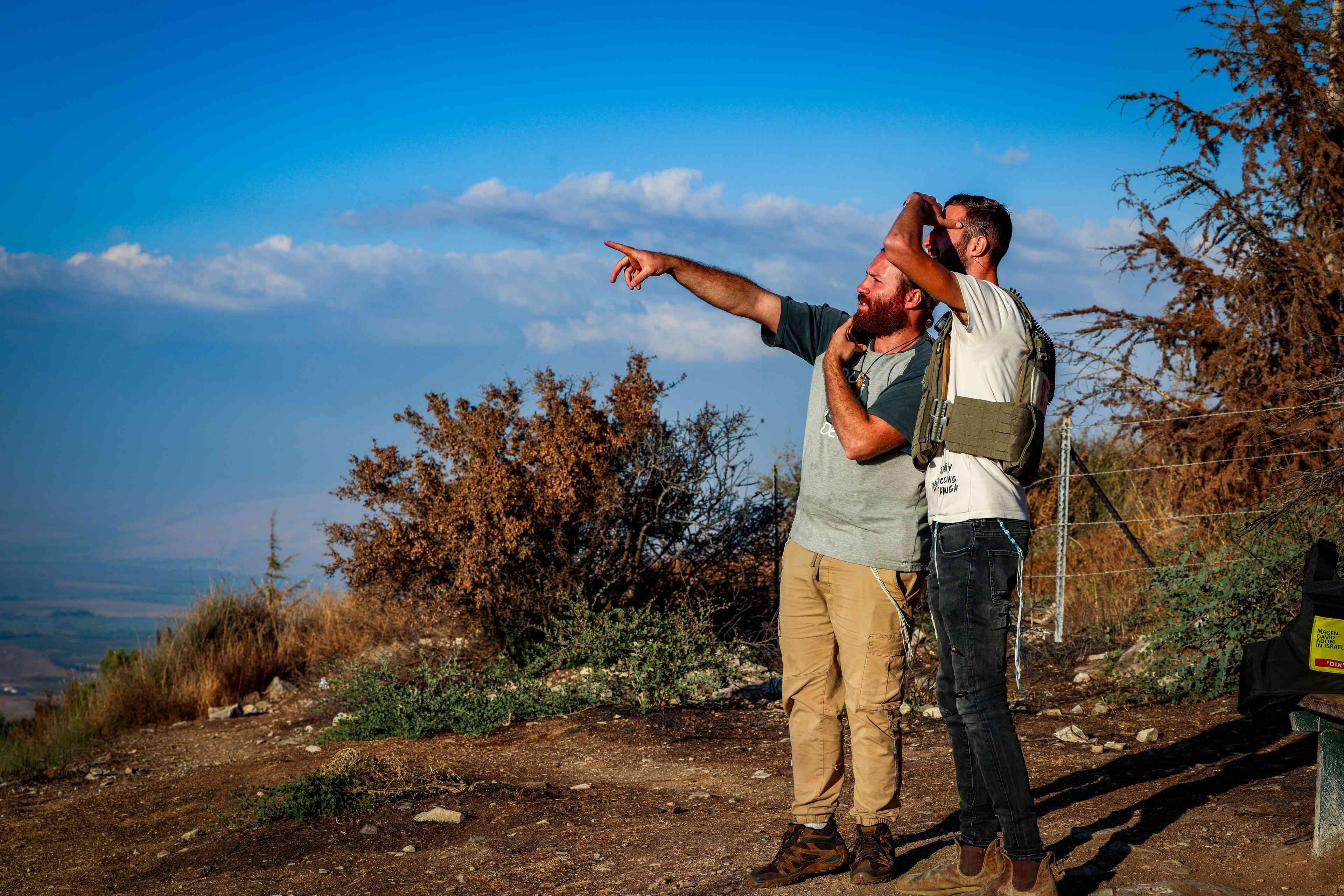 People watch Israeli air strikes in southern Lebanon, near the Israeli border with Lebanon, September 23, 2024. background