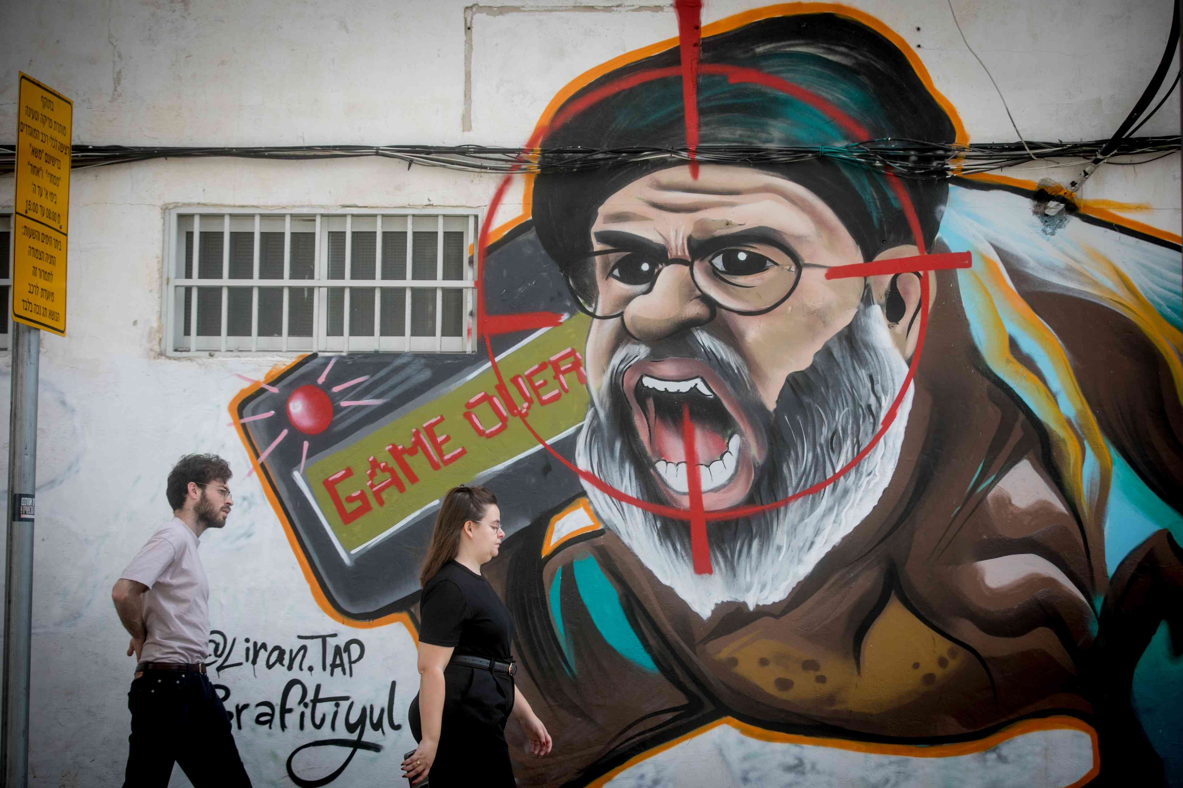 Graffiti showing Hazbollah leader Hassan Nasrallah, in Tel Aviv, two days after Israel's assassination of the leader in Beirut background