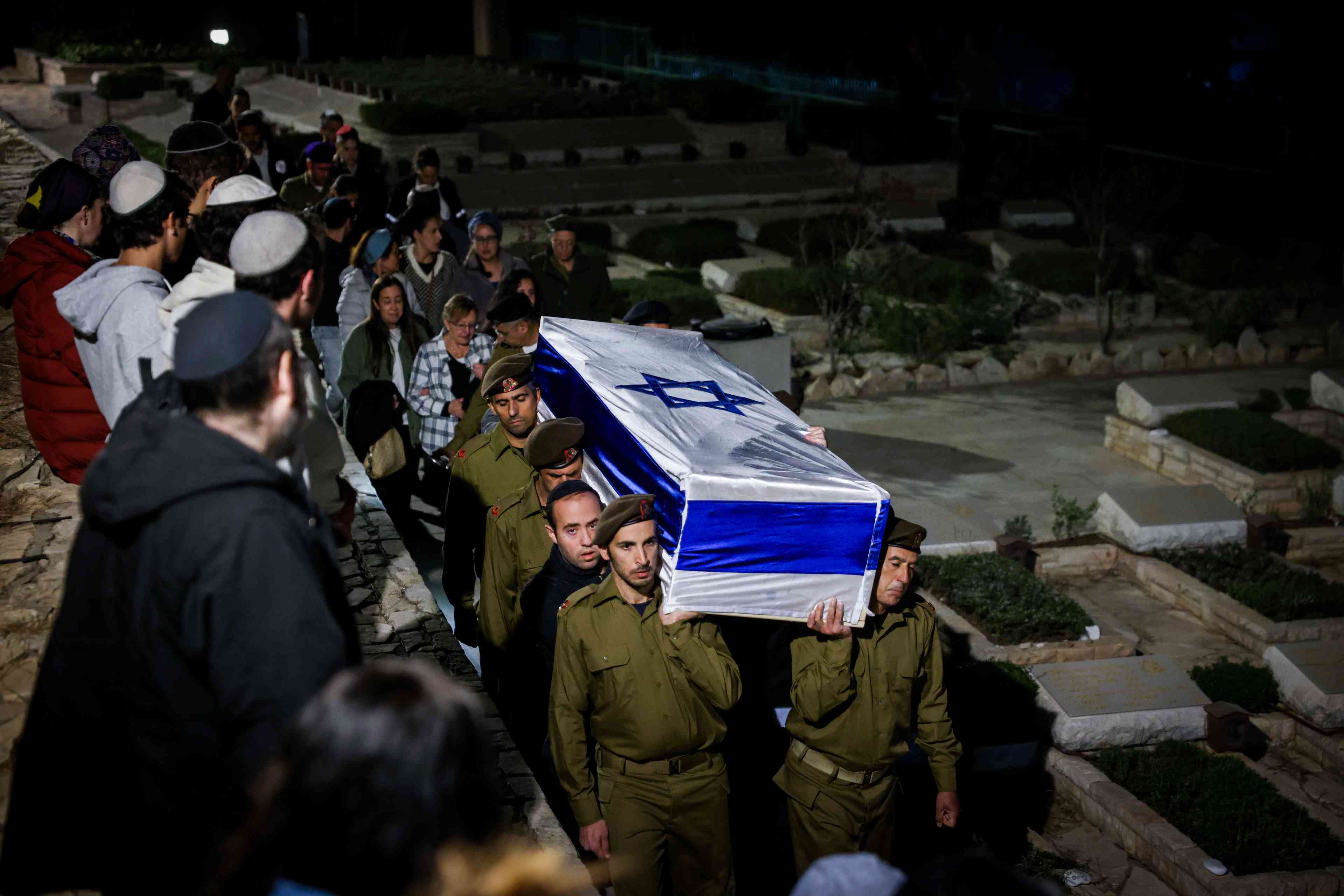 People attend the funeral of Israeli soldier Sergeant major (res.) Shmuel Harari at Mount Herzl Military Cemetery in Jerusalem on October 26, 2024 background
