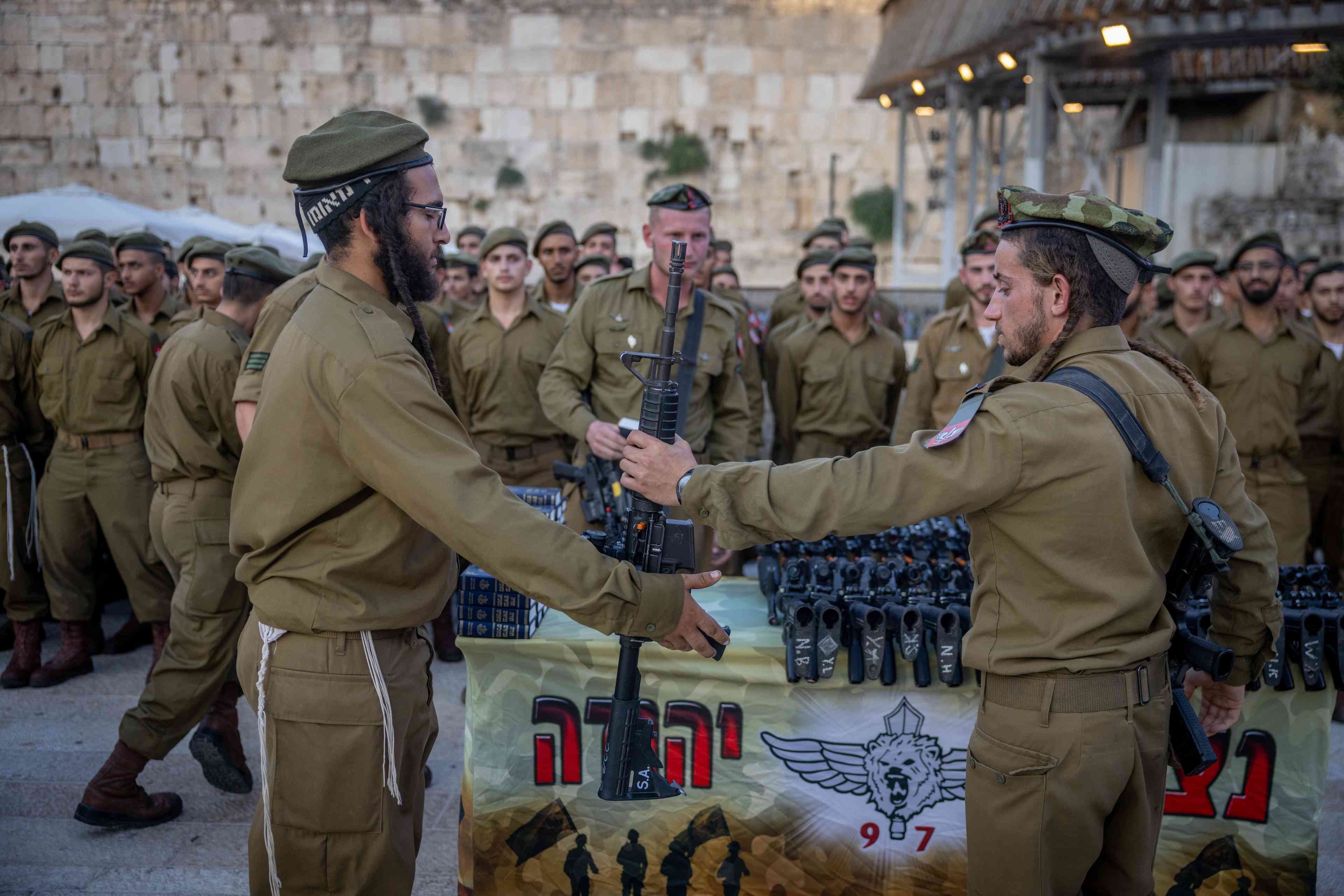 Israeli soldiers from Netzah Yehuda at a swearing-in ceremony at the Western Wall in Jerusalem's Old City, on July 10, 2024.  background