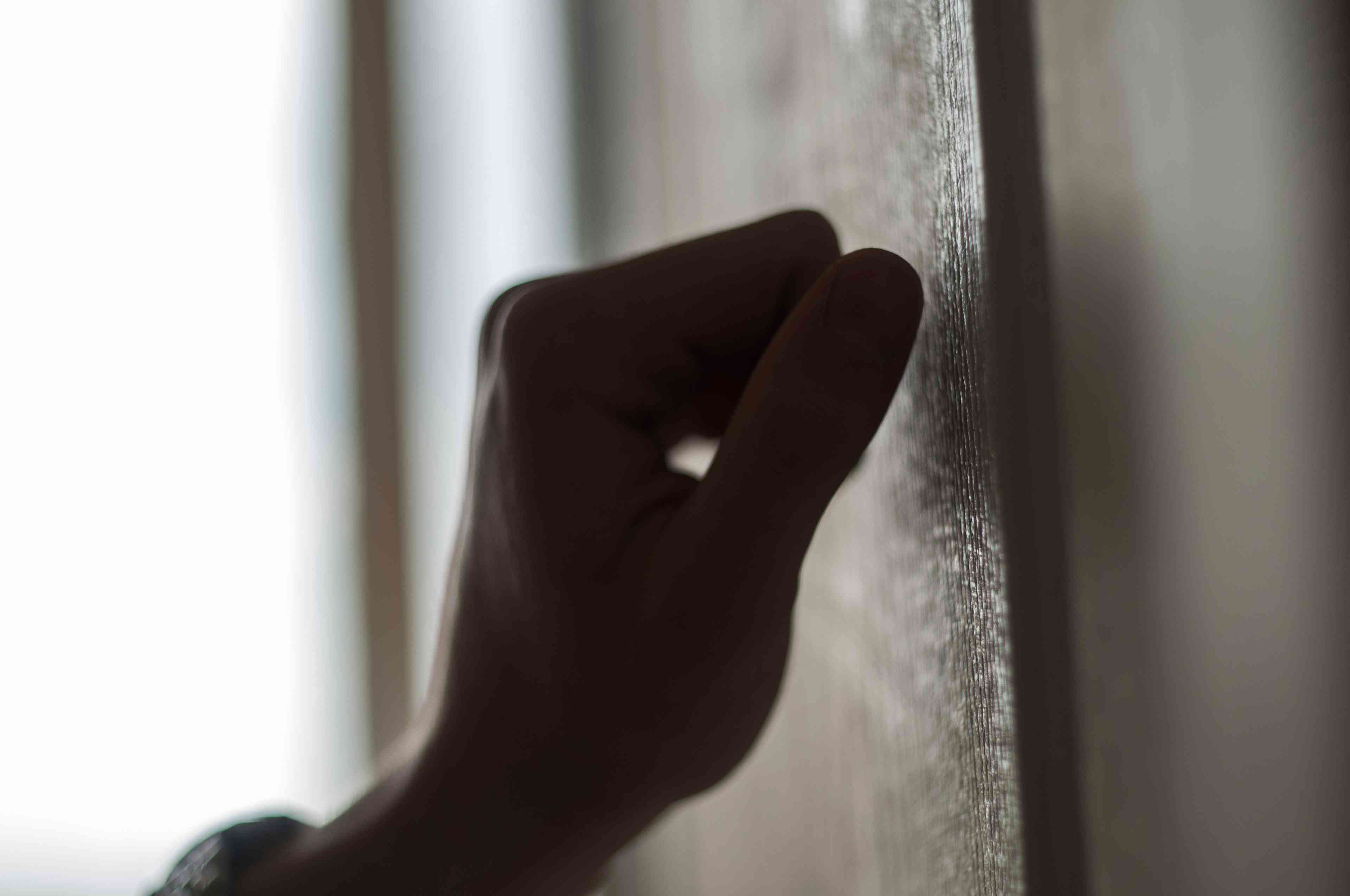 Hand knocking on the door background
