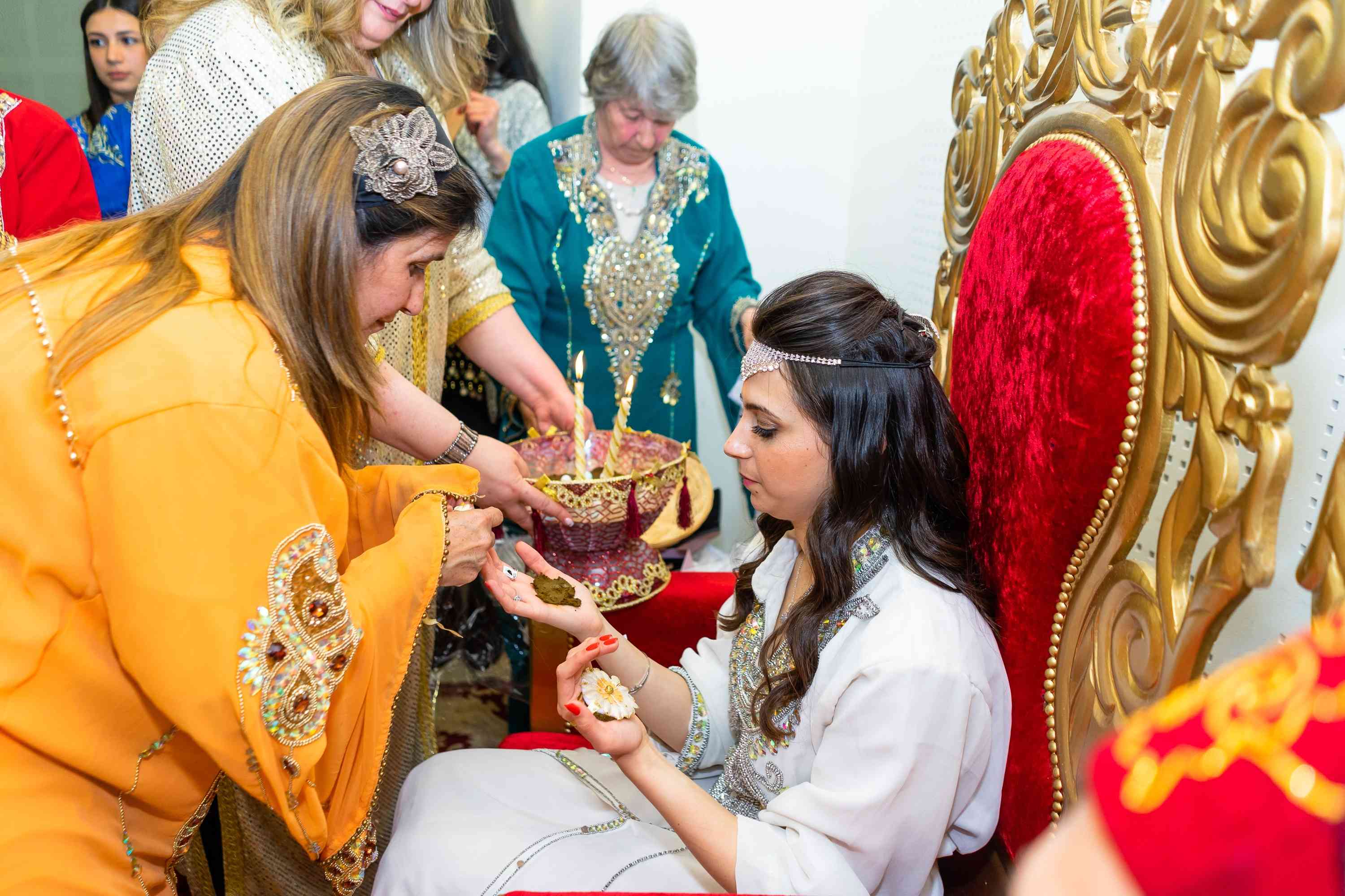 Woman puts henna on bride's palm during henna ceremony - Moroccan Jewish Henna Wedding background