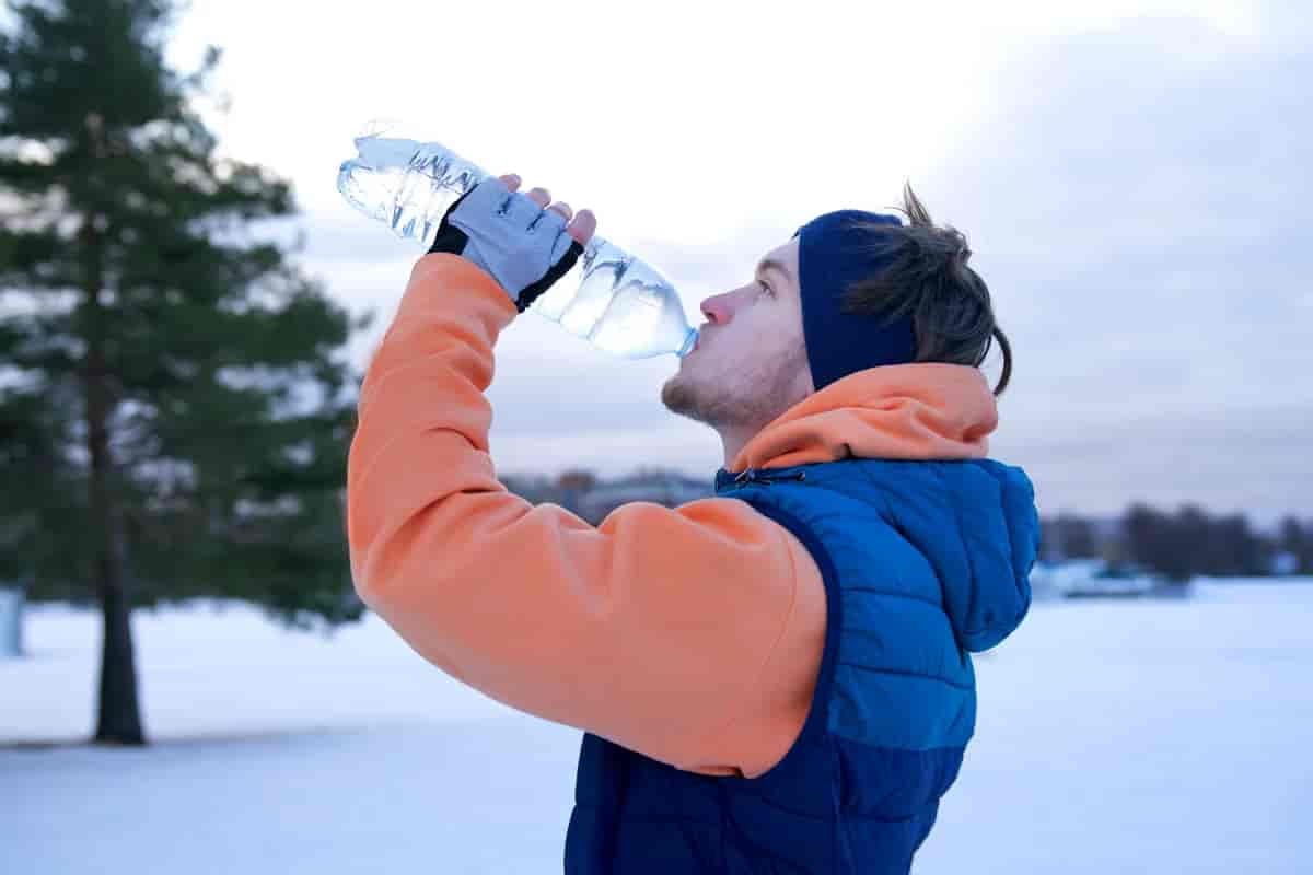 Man drinking water in winter background