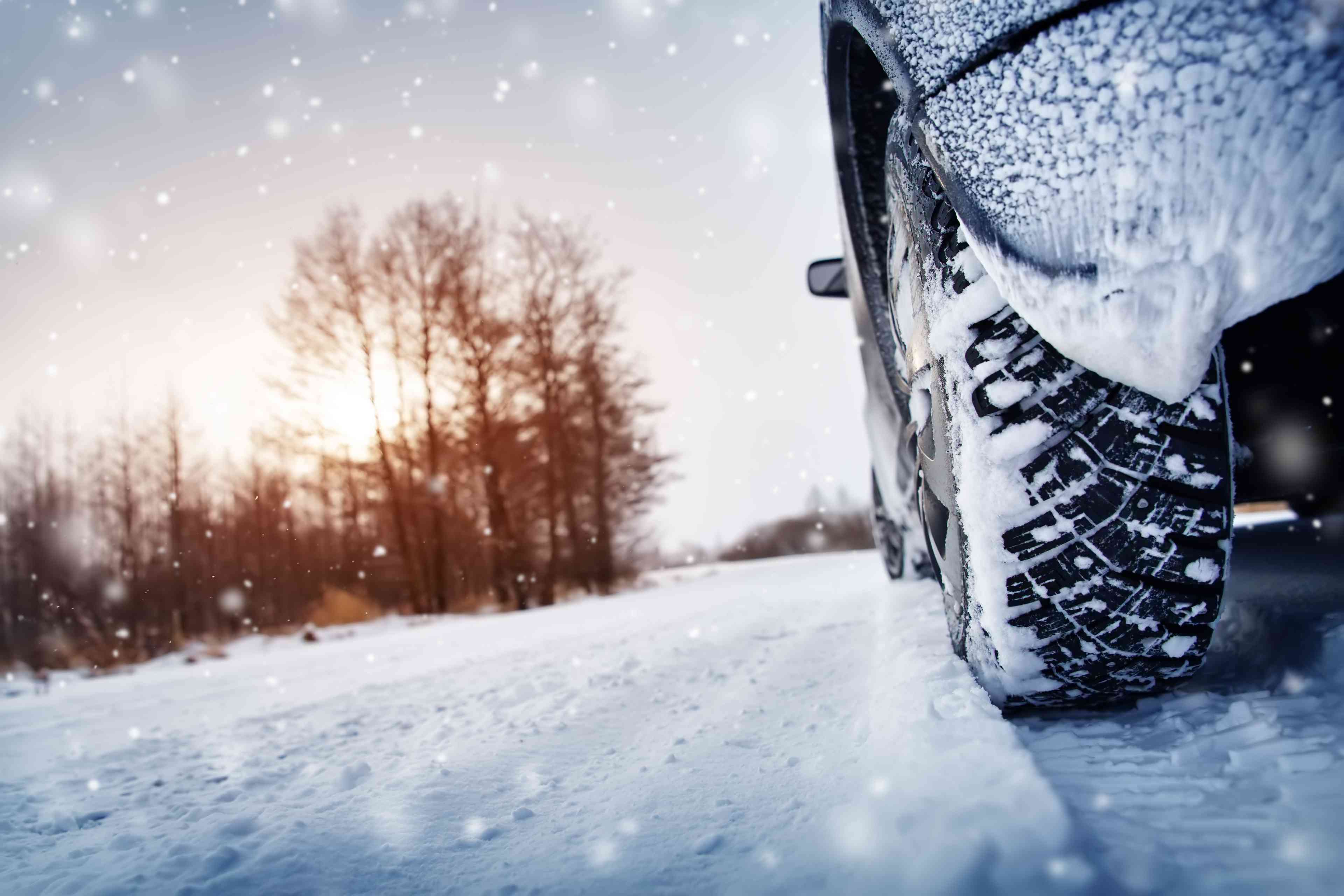 Car tires on winter road covered with snow background