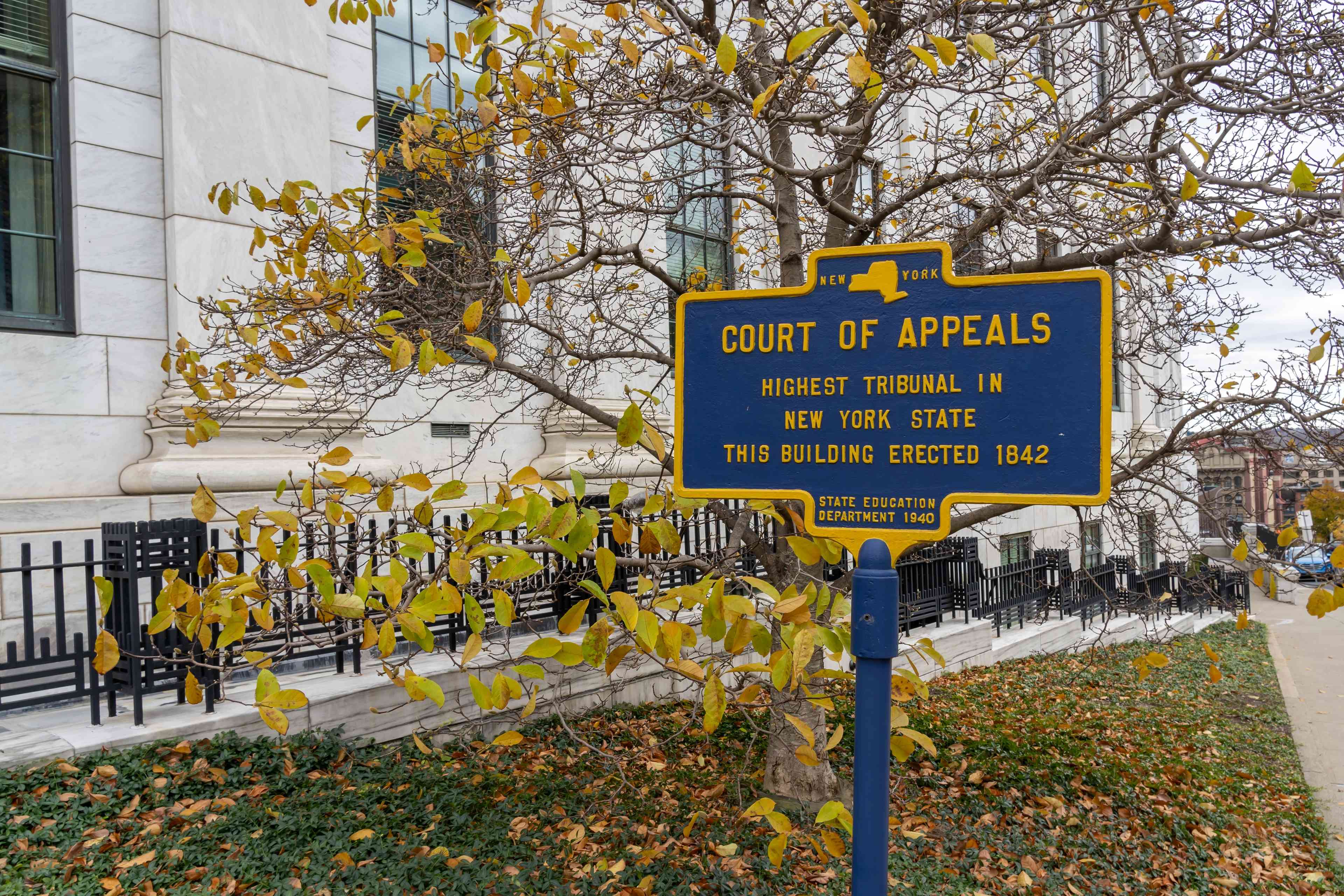 A metal historical marker with Inscription “Court of Appeals, Highest Tribunal in New York State" background